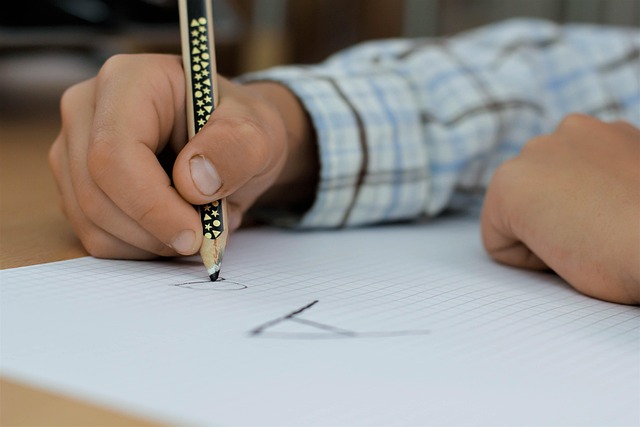 Hand writing with a fountain pen in an open notebook on a wooden desk