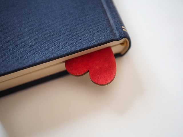Open book beside a notebook with handwritten notes