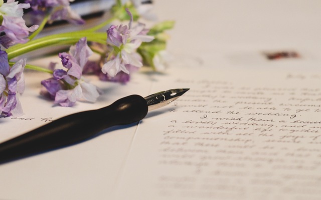 Dip pen creating calligraphic letters with black ink on quality paper