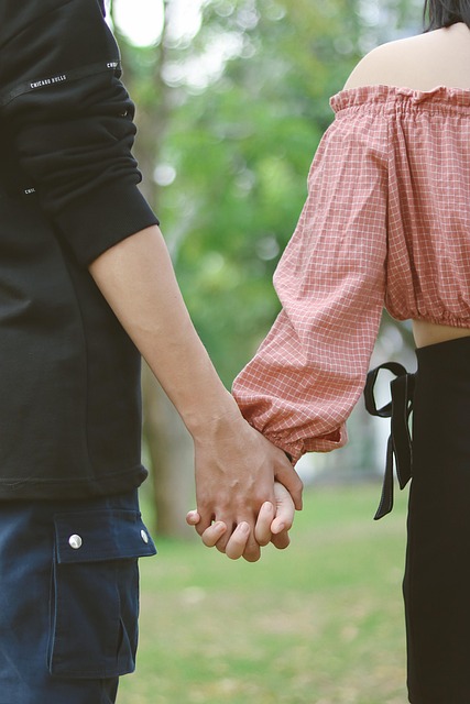 Hand holding a fountain pen writing cursive letters on lined notebook paper with natural daylight