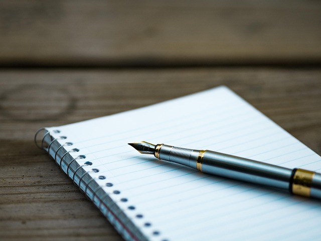 Open notebook with handwritten English words and spelling corrections on a writing desk