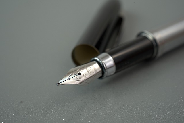 Fountain pens, ink bottles and textured writing paper on a desk