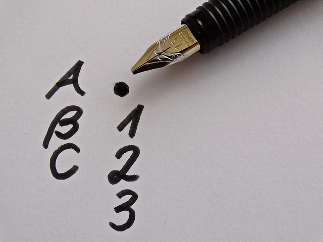 Fountain pens, ink bottles and quality paper arranged on a wooden desk